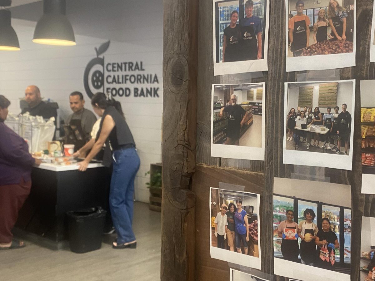 Volunteers at the Fruits First Market assisting Fresno “neighbors” get their groceries
aside a polaroid photo board on sept. 18.