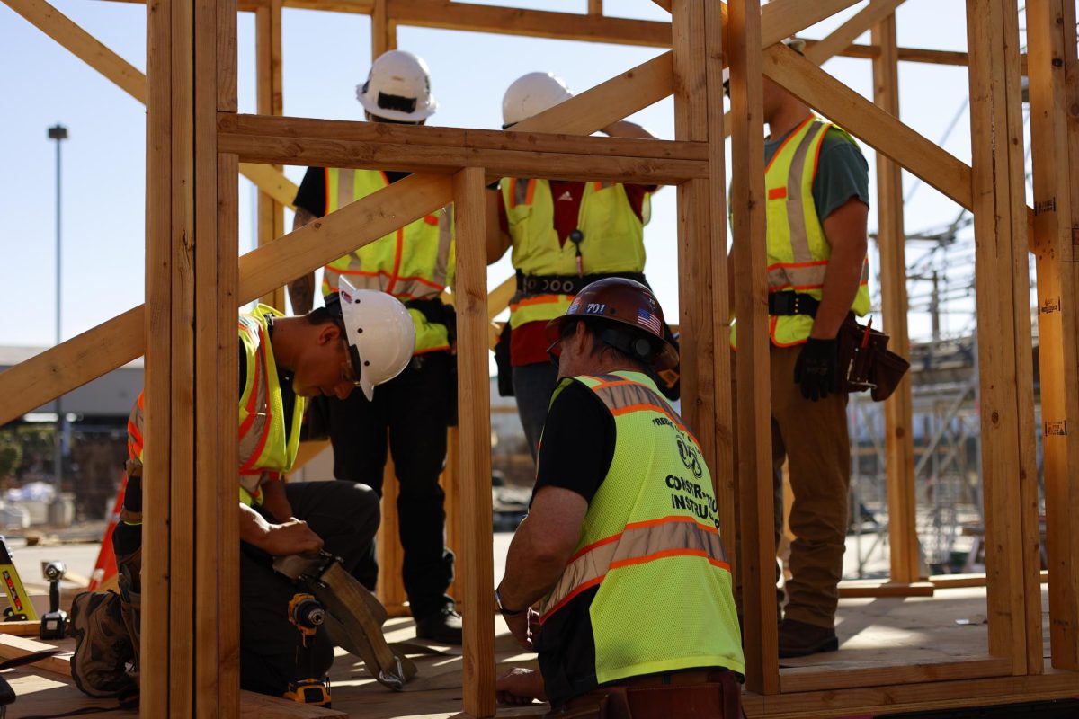 A group of students huddle around a FCC construction instructor
learning how to “square up” a building.