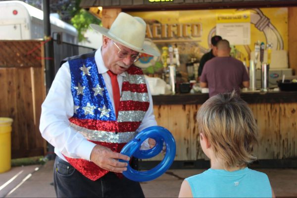 Dennis Forel makes a snake balloon animal for a child at The Big Fresno Fair on Oct. 10, 2024. 