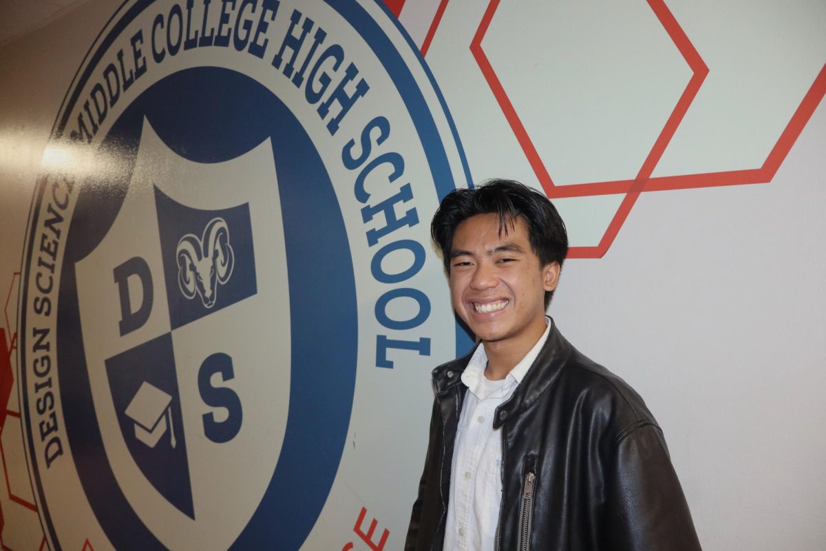 Evan-Kyle Sackdavone, a senior at Design Science Middle College High School, poses in front of the DSMCHS emblem on Nov. 6.