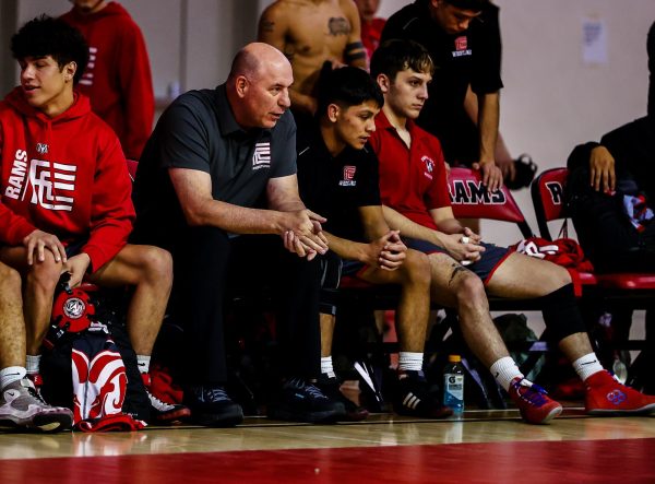 Fresno City College Wrestling Coach Paul Keysaw sits alongside his team during their match against San Joaquin Delta College on Nov. 14. Keysaw marked a significant milestone, celebrating his 300 career wins as head coach.