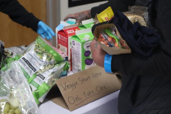 A patient grabs free milk and food with a bag of fentanyl testing strips
and syringes in hand in the Fresno County Department of Public Health
building on Nov. 23.