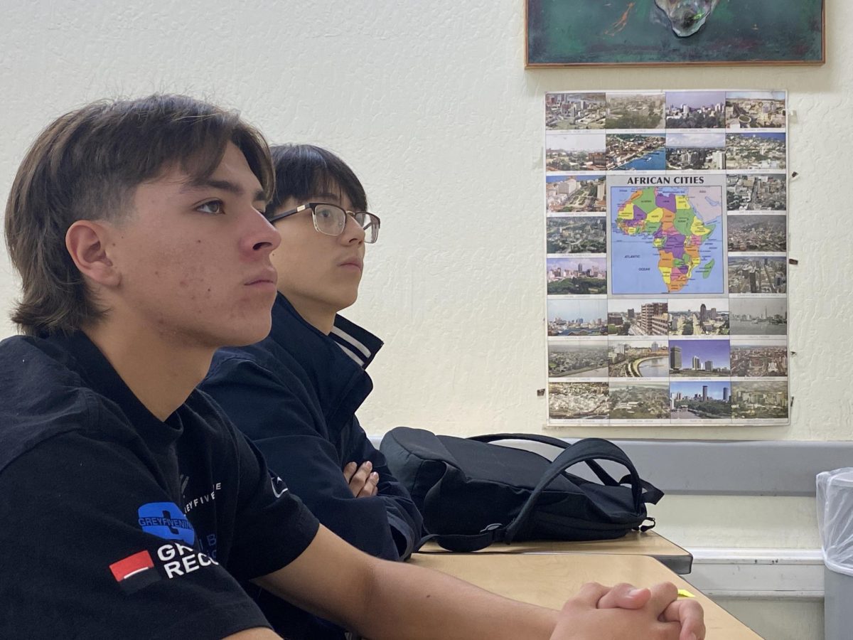 Mason Medina (left) and Leonel Tapia (right) pay attention to professor Auguste Kouadio in their Intro to African American Studies class on Nov. 21.