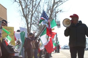 Protest organizer Leonel Flores leads a chant through his speakerphone to the immigration rights demonstrators gathered at the corner of Blackstone and Nees on Jan. 20.