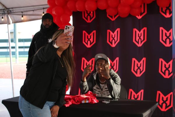 National Football League wide receiver for the Kansas City Chiefs’, Xavier Worthy, poses for a picture with a fan after signing her jersey on Feb. 19, 2025.