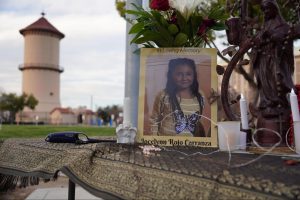 A table with flowers, candles, a cross and a photo titled “In Loving Memory Jocelynn Rojo Carranza” at Eaton Plaza for a vigil on March 1, 2025.